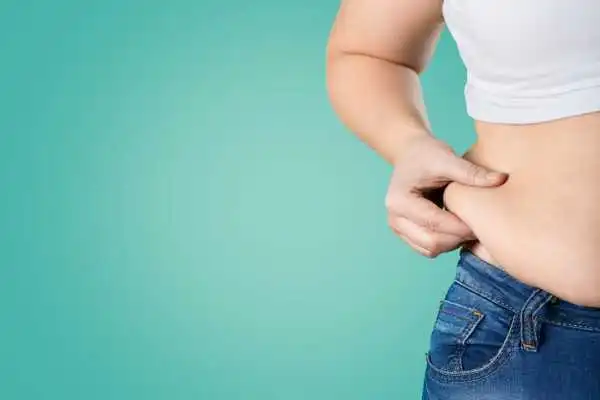 Image of woman pinching her love handles to show weight gain Clacton